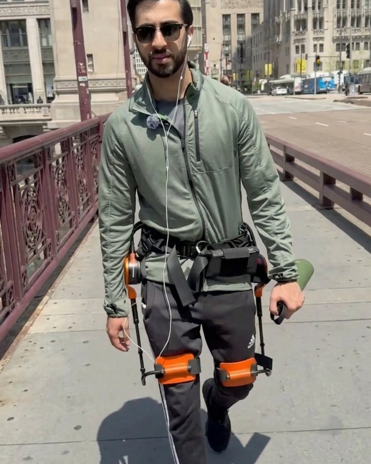 A man is walking on the street wearing the first generation of RoboCT GoGo H exoskeleton.