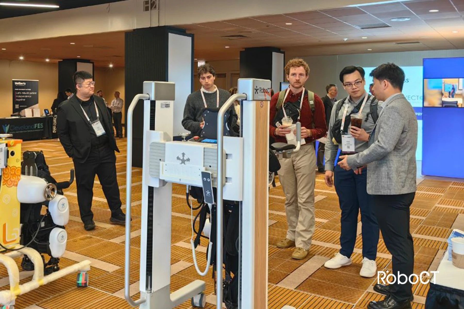 Group of people learn about the RoboCT medical exoskeleton for rehabilitation at RehabWeek Chicago 2025.