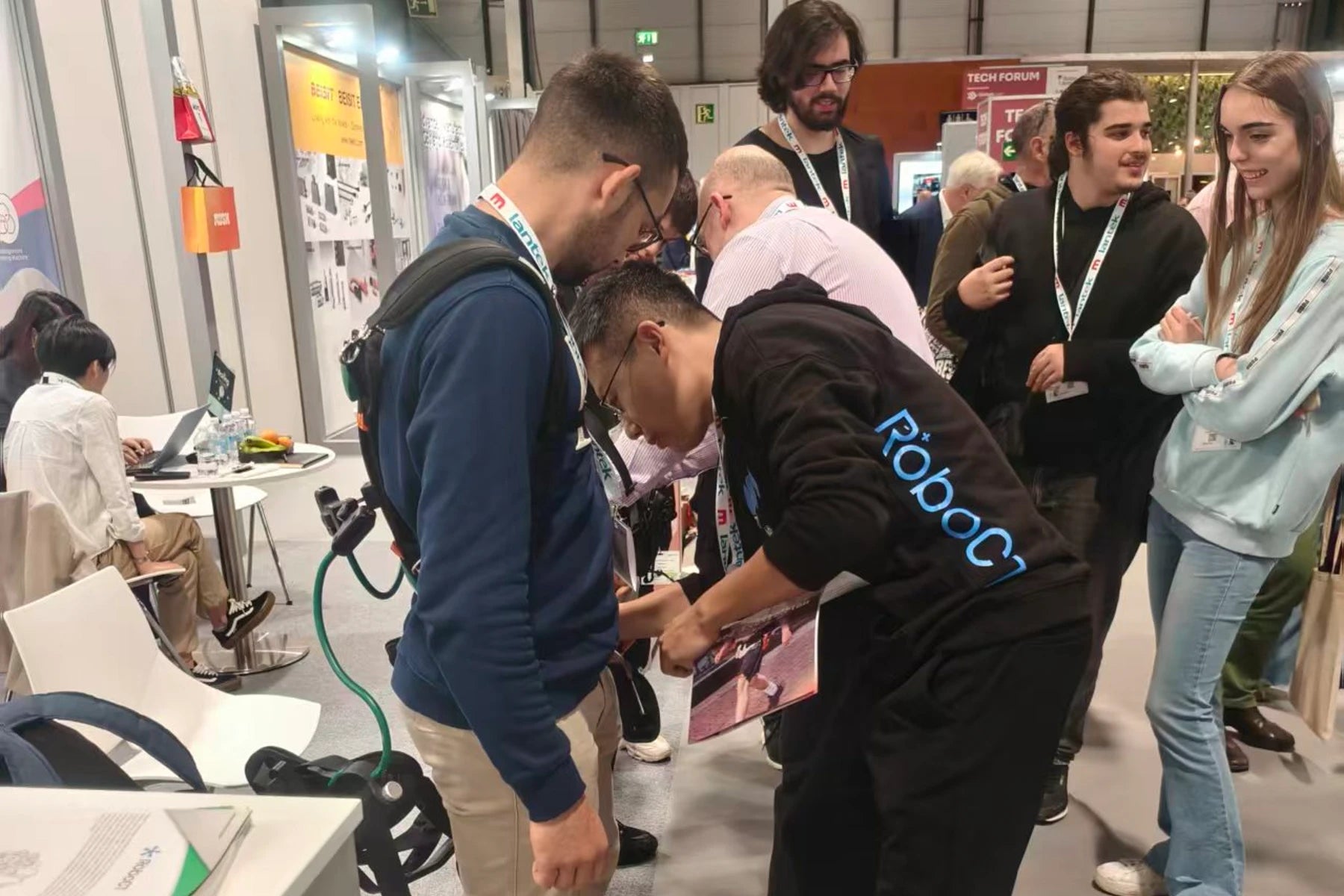 People interacting with the RoboCT exoskeleton robot at Robomatica Madrid 2025.